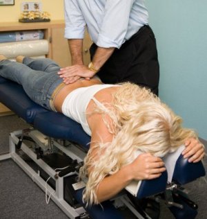 chiropractor laying hands on sacral spine