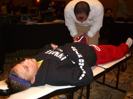 chiropractor assessing individual on adjusting table